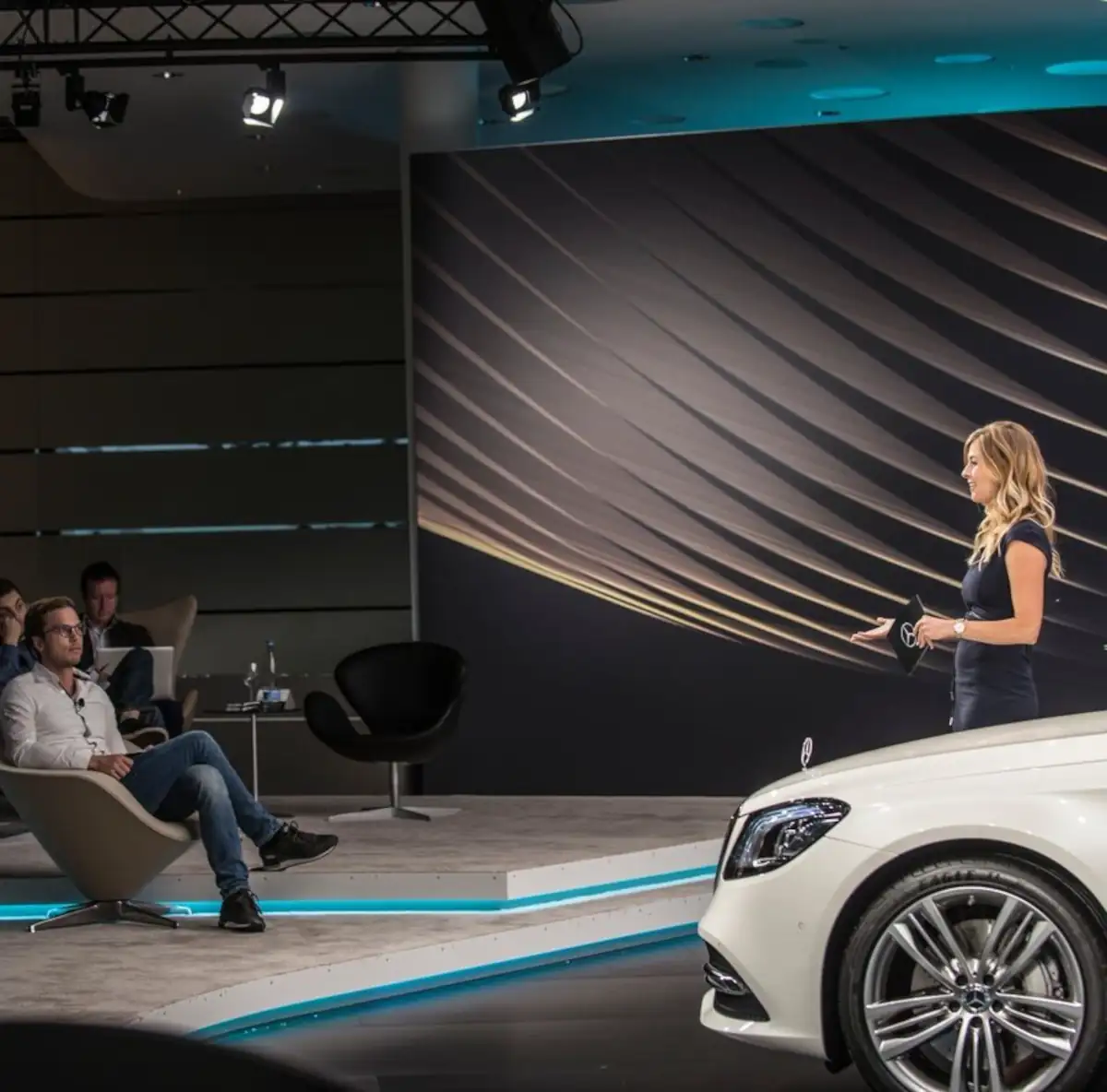 Moderatorin präsentiert ein Auto vor Publikum bei einer Automobil-Veranstaltung