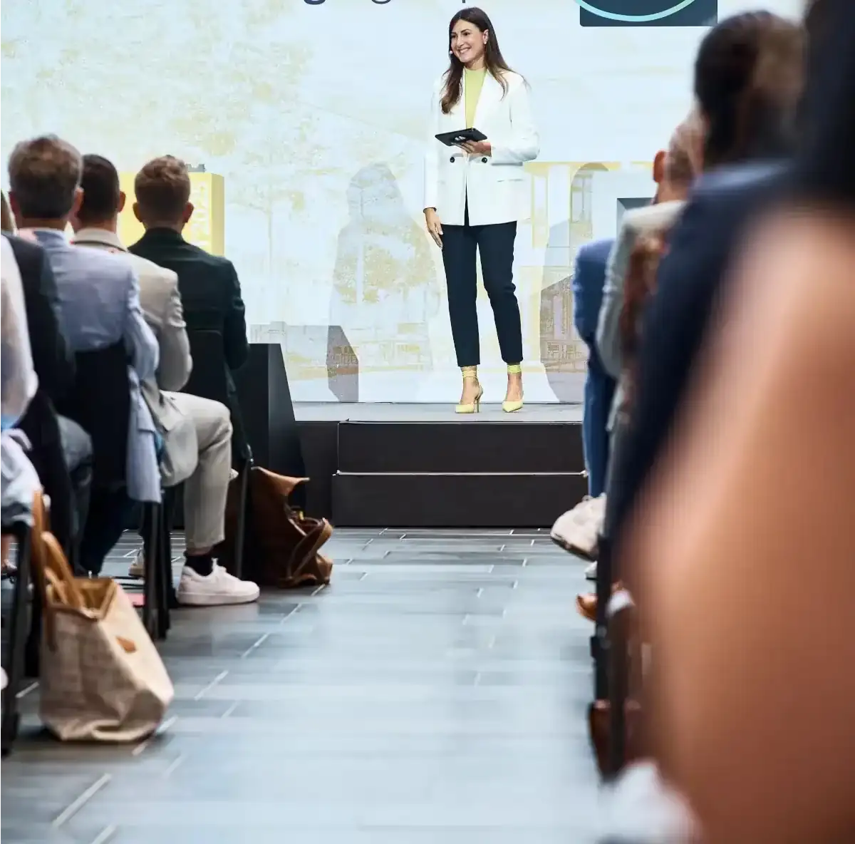 Moderatorin moderiert ein Business-Event vor Publikum.